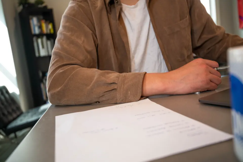 Une personne remplit un formulaire à son bureau