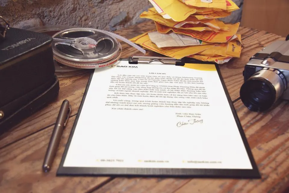 Un courrier et un stylo posés sur un bureau en bois